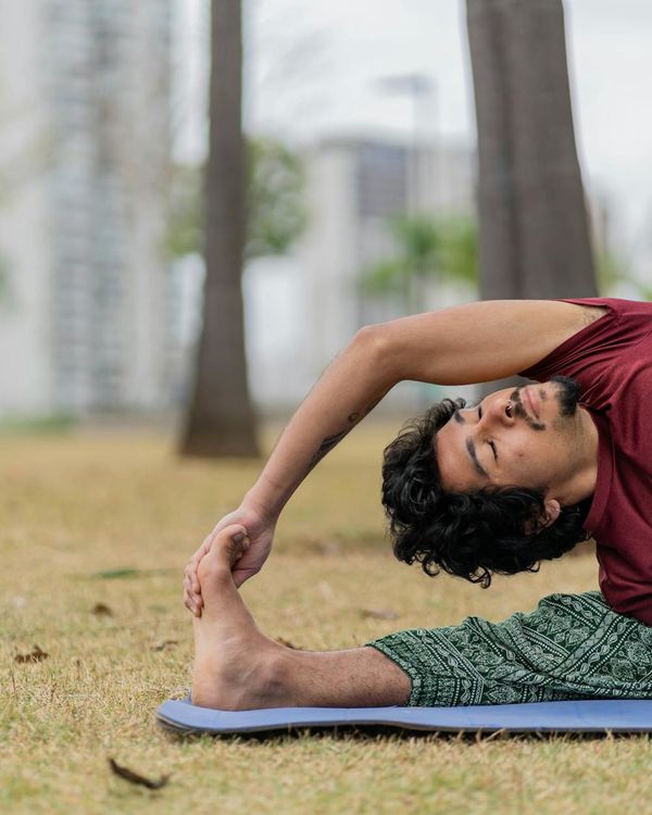 Man stretching outdoors with a serene natural background.